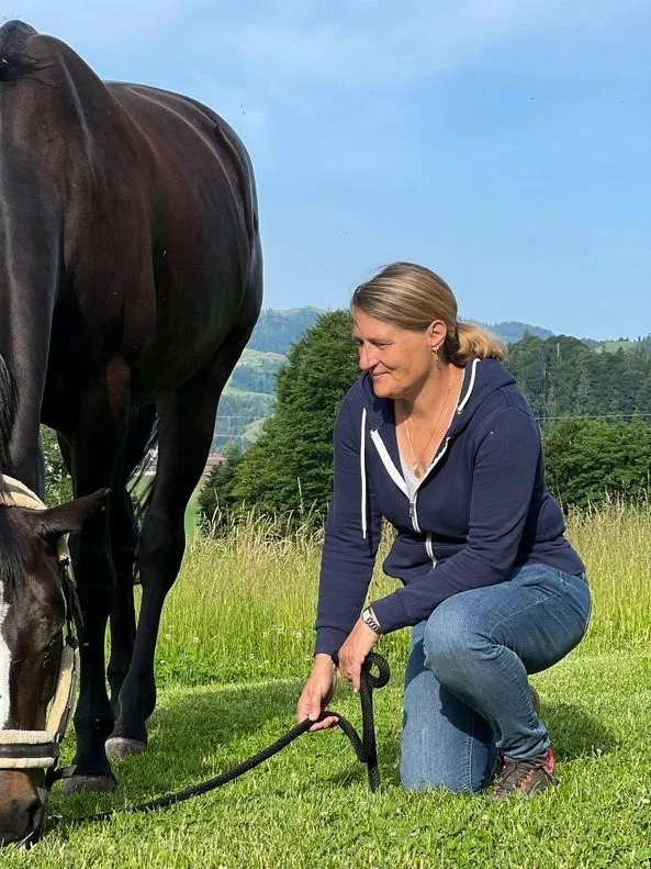 Astrid Brun-Bühlmann mit einem Pferd auf der Weide
